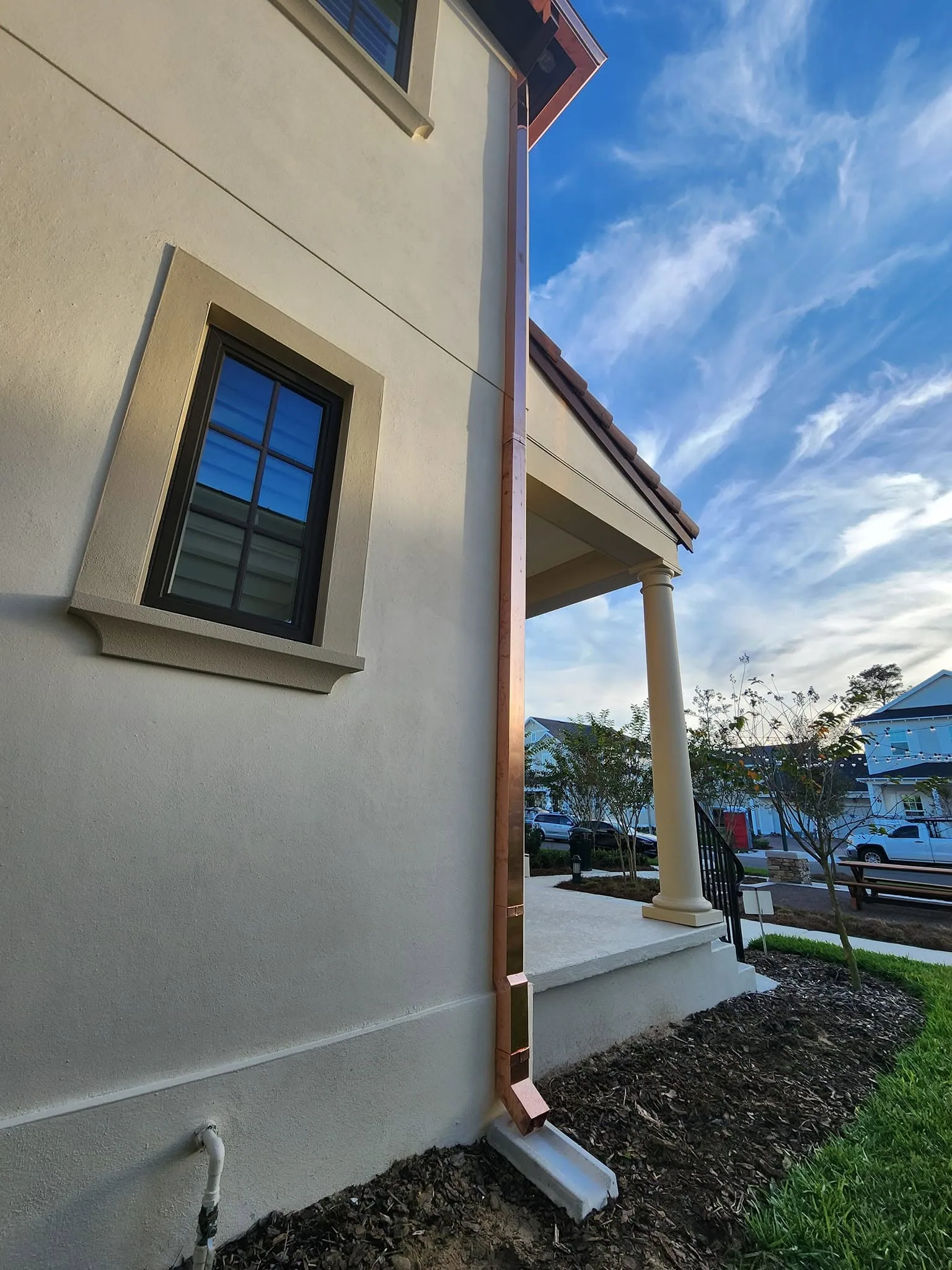 Copper square downspout cream stucco porch column splash block, Sanford